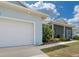 Home's exterior featuring a two-car garage, covered porch, and vibrant landscaping at 2229 Wakefield St, Port Charlotte, FL 33948