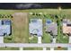 Aerial view of three homes with pools, green lawns, a canal, and a street at 229 Sportsman Rd, Rotonda West, FL 33947