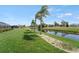 Beautiful backyard with lush green grass, palm trees, and canal view at 229 Sportsman Rd, Rotonda West, FL 33947