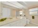 Bathroom featuring an extended vanity with white cabinets, a neutral countertop, and an oversized mirror at 229 Sportsman Rd, Rotonda West, FL 33947