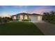 Charming home with a well-manicured lawn and beautiful sunset sky at 229 Sportsman Rd, Rotonda West, FL 33947