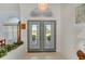 Bright foyer features gray double doors, a decorative chandelier, tile flooring, and views of the landscaped front yard at 229 Sportsman Rd, Rotonda West, FL 33947