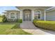 Inviting front entrance with arched windows, columns, security gate, and a stone walkway leading to the front door at 229 Sportsman Rd, Rotonda West, FL 33947