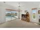 Bright living room featuring a ceiling fan and sliding glass doors to a screened-in pool and outdoor space at 229 Sportsman Rd, Rotonda West, FL 33947