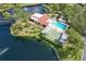 Beautiful aerial view of community pool, clubhouse, and bocce ball court surrounded by a pond at 23465 Harborview Rd # 842, Port Charlotte, FL 33980