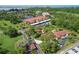 An aerial view features a low-rise apartment building near a lake and covered parking area at 23465 Harborview Rd # 842, Port Charlotte, FL 33980