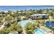 Aerial view of community tennis courts, pool, and lake, nestled among lush trees and landscaping at 23465 Harborview Rd # 842, Port Charlotte, FL 33980