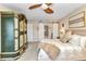 Bedroom with an antique wardrobe, ceiling fan and sliding barn door to the bathroom at 23465 Harborview Rd # 842, Port Charlotte, FL 33980