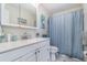Bright bathroom featuring white cabinets, a large mirror, a toilet and a shower with curtain at 242 Seminole Nw Blvd, Port Charlotte, FL 33952