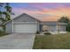 Single-story home boasts a large garage door, well-maintained lawn, and welcoming curb appeal at 242 Seminole Nw Blvd, Port Charlotte, FL 33952
