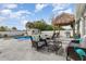 Outdoor seating area next to pool features plush seating arrangements and a tiki hut with bar at 242 Seminole Nw Blvd, Port Charlotte, FL 33952