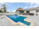 Large inground pool surrounded by a patio area with tiki bar and outdoor seating, providing ample space for relaxation at 242 Seminole Nw Blvd, Port Charlotte, FL 33952