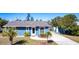 Single-story home with blue siding, palm trees in the front yard, and long concrete driveway at 3249 Cedarbrook Dr, Punta Gorda, FL 33982