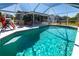 A shimmering pool with a screened enclosure and outdoor seating area at 3249 Cedarbrook Dr, Punta Gorda, FL 33982