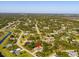 Aerial view showcasing a home nestled among lush greenery in a quiet neighborhood with serene and inviting atmosphere at 3476 Brewster Rd, North Port, FL 34288