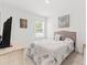Bedroom with neutral decor, a grey bed, and a window with a view of a green yard at 3476 Brewster Rd, North Port, FL 34288