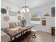 Bright dining area features modern chandelier, wood table, and window views at 3476 Brewster Rd, North Port, FL 34288