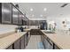 Open kitchen with dark cabinets, stainless appliances, large island, and view to dining area at 3476 Brewster Rd, North Port, FL 34288