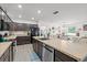 Open concept kitchen flows into dining with dark cabinets, stainless appliances, and an island with a sink at 3476 Brewster Rd, North Port, FL 34288