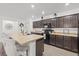 Spacious kitchen with dark cabinetry, sleek appliances, a large center island with seating at 3476 Brewster Rd, North Port, FL 34288