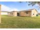 Rear exterior view of the house highlighting the backyard, siding, and outdoor access at 3480 Pinetree St, Port Charlotte, FL 33952