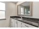 Bathroom featuring granite counters, white cabinets, and modern fixtures at 3480 Pinetree St, Port Charlotte, FL 33952