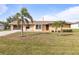 Attractive single-Gathering home with a tidy lawn, complemented by decorative palm trees at 3480 Pinetree St, Port Charlotte, FL 33952