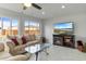 Comfortable living room featuring plush sofas, a modern fireplace, and a large screen TV at 3480 Pinetree St, Port Charlotte, FL 33952