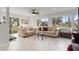 Open-concept living room with tile flooring, neutral furniture, and large windows for natural light at 3480 Pinetree St, Port Charlotte, FL 33952