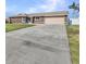 One-story home with extended driveway leading to the attached garage and well-manicured lawn at 4178 Rose Arbor Cir, Port Charlotte, FL 33948