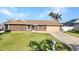 Single-story home with a well-manicured lawn, two-car garage, and welcoming front entrance at 4178 Rose Arbor Cir, Port Charlotte, FL 33948