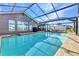 Tranquil pool area featuring a screened enclosure, providing privacy and protection while overlooking the peaceful waterway at 4178 Rose Arbor Cir, Port Charlotte, FL 33948