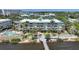 Aerial view of the condo complex with manicured landscaping, a pier, and the peaceful waterfront at 5114 Melbourne St # A202, Punta Gorda, FL 33980