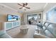 Bright living room featuring a ceiling fan, balcony access, and comfortable seating at 5114 Melbourne St # A202, Punta Gorda, FL 33980