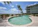 Inviting pool area with comfortable seating, picturesque landscaping, and a nearby building at 5114 Melbourne St # A202, Punta Gorda, FL 33980