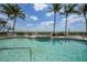 Relaxing pool area featuring lounge chairs and tables surrounded by lush greenery and palm trees at 5114 Melbourne St # A202, Punta Gorda, FL 33980