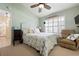 Bright bedroom with comfortable chair, white shuttered window, ensuite bath, and coastal decor at 5390 Brassy Loop, North Port, FL 34287