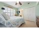 Coastal bedroom featuring shuttered window, mounted TV, ensuite bathroom and closet at 5390 Brassy Loop, North Port, FL 34287