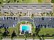 A sunny aerial view shows a pool surrounded by condos, parking and lush landscaping at 5416 Swift Rd # 27, Sarasota, FL 34231