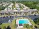 An aerial view of a condominium complex features a sparkling swimming pool and ample parking surrounded by mature landscaping at 5416 Swift Rd # 27, Sarasota, FL 34231