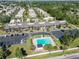 An aerial view of a condominium complex features a sparkling swimming pool and ample parking surrounded by mature landscaping at 5416 Swift Rd # 27, Sarasota, FL 34231