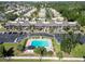 An aerial view of a condominium complex features a sparkling swimming pool and ample parking surrounded by mature landscaping at 5416 Swift Rd # 27, Sarasota, FL 34231