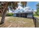 Spacious fenced backyard with a screened-in porch and lush landscaping offers privacy at 6329 David Blvd, Port Charlotte, FL 33981