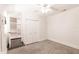 Bright bedroom featuring gray carpet, a ceiling fan, and a door leading to a closet with shelves at 6329 David Blvd, Port Charlotte, FL 33981