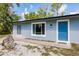 Charming single-story home with a well-manicured lawn and a bright blue front door at 6329 David Blvd, Port Charlotte, FL 33981