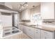 Modern kitchen featuring granite countertops, white cabinetry, tile backsplash, and stainless appliances at 6329 David Blvd, Port Charlotte, FL 33981