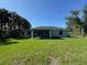 Rear view of home features a well-manicured lawn and screened in lanai at 6346 Lachine Ave, North Port, FL 34291