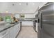 This kitchen boasts stainless appliances, granite countertops, white cabinetry, and a center island with a sink at 6346 Lachine Ave, North Port, FL 34291