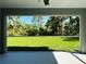 Screened-in patio offering scenic backyard views with green grass and trees at 6346 Lachine Ave, North Port, FL 34291