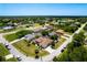 Wide aerial shot of the house in a residential neighborhood with green trees and blue skies at 8315 Raoul Ave, North Port, FL 34291